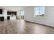Open-concept living space with durable wood-look flooring, bright natural light, and seamlessly connected kitchen area at 14412 Heritage Dr, Mead, CO 80504