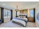Primary bedroom boasts ample natural light, elegant chandelier, and stylish wood accent wall at 14412 Heritage Dr, Mead, CO 80504