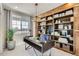 Comfortable office space features custom built in shelving, stylish lighting, and a large window at 14412 Heritage Dr, Mead, CO 80504