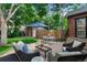 Inviting backyard patio with comfortable seating, table, shade umbrella and verdant green yard at 1040 S Elizabeth St, Denver, CO 80209