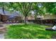 Serene backyard with lush green lawn, mature trees, and a patio perfect for relaxing or entertaining guests at 1040 S Elizabeth St, Denver, CO 80209