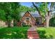 Quaint brick home featuring a well-manicured front lawn and garden, complemented by a charming arched porch entry at 1040 S Elizabeth St, Denver, CO 80209