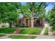 Charming brick home with manicured lawn and garden, a welcoming front porch, and a convenient driveway at 1040 S Elizabeth St, Denver, CO 80209