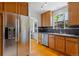 Well-lit kitchen with stainless steel refrigerator, wood cabinets, and a view to the breakfast nook at 1040 S Elizabeth St, Denver, CO 80209