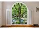 Arched window with shutters provides stunning views of the neighborhood in this stylish living room at 1040 S Elizabeth St, Denver, CO 80209
