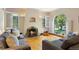 Cozy living room with a decorative fireplace, light wood floors, and an arched window with shutters at 1040 S Elizabeth St, Denver, CO 80209