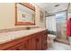 Bathroom featuring granite countertop, wood cabinets, and tiled shower with glass door at 838 S 10Th Ave, Brighton, CO 80601