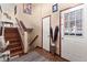 Inviting foyer with hardwood stairs, decorative vase, and a front door with glass panes at 838 S 10Th Ave, Brighton, CO 80601