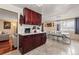 Open kitchen area with dark wood cabinets, view into living room, and tile flooring at 838 S 10Th Ave, Brighton, CO 80601