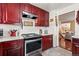 Functional kitchen with dark wood cabinetry, tile floors, and modern stainless steel appliances at 838 S 10Th Ave, Brighton, CO 80601