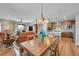 Open-concept dining area with modern chandelier, hardwood floors, and seamless living space integration at 8492 Arriba Dr, Littleton, CO 80125