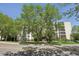 Inviting condominium exterior with mature trees, lush landscaping, and well-maintained facade at 3465 S Poplar St # 305, Denver, CO 80224