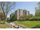 Exterior view of a multi-story building featuring a well-maintained lawn and creek at 3465 S Poplar St # 305, Denver, CO 80224