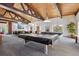 Community game room showcasing billiards tables, tables and chairs, and brick accent wall with large TV at 3465 S Poplar St # 305, Denver, CO 80224