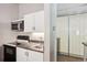 Efficient kitchen featuring white cabinets, modern appliances, and a sliding glass door at 3465 S Poplar St # 305, Denver, CO 80224
