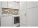 Laundry room with a washer, dryer and storage cabinets at 3465 S Poplar St # 305, Denver, CO 80224