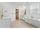 Bright bathroom with double vanity, soaking tub, tile flooring, and walk-in closet access at 16537 Black Rose Cir, Parker, CO 80134