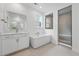 Modern bathroom with soaking tub, glass-enclosed shower, double vanity, and tile flooring at 16537 Black Rose Cir, Parker, CO 80134