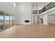 Bright living room with tall ceilings, wood floors, a fireplace, and access to the outdoor patio at 16537 Black Rose Cir, Parker, CO 80134
