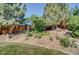 Manicured backyard featuring mature trees, lush landscaping, and a rock garden at 6379 Holman Ct, Arvada, CO 80004