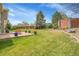 Large grassy backyard offering ample space for recreation and relaxation with a brick feature at 6379 Holman Ct, Arvada, CO 80004