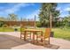 A serene backyard with a wooden dining set on a brick patio beneath a clear blue sky at 6379 Holman Ct, Arvada, CO 80004