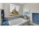 Relaxing bathtub area with a large window offering views of the lush greenery outside at 6379 Holman Ct, Arvada, CO 80004