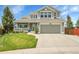 Charming two-story home with a well-manicured lawn, front porch, and attached two-car garage at 6379 Holman Ct, Arvada, CO 80004
