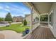 Inviting front porch with wood flooring, white railings, and well-maintained landscaping at 6379 Holman Ct, Arvada, CO 80004