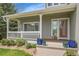 Inviting front porch with decorative columns and lush greenery at 6379 Holman Ct, Arvada, CO 80004