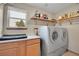 Bright laundry room featuring a modern washer and dryer with ample shelving space at 6379 Holman Ct, Arvada, CO 80004