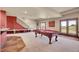 Open basement featuring a pool table, shuffleboard, and walkout access, ideal for recreational activities at 4959 Rocky View Pt, Castle Rock, CO 80108