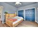 Comfortable bedroom with blue walls, modern closet doors, and ample natural light at 4959 Rocky View Pt, Castle Rock, CO 80108
