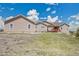 The exterior features a home with light siding, showcasing a spacious lawn under a vibrant blue sky with fluffy clouds at 4959 Rocky View Pt, Castle Rock, CO 80108