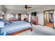 Spacious bedroom with wooden furniture, ceiling fan, and a large TV cabinet, creating a relaxing ambiance at 4959 Rocky View Pt, Castle Rock, CO 80108