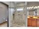 Tiled walk-in shower with a small window, dual shower heads, and decorative pebble flooring at 4959 Rocky View Pt, Castle Rock, CO 80108