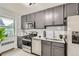 Modern kitchen with sleek gray cabinets, stainless steel appliances, and stylish backsplash and a plant near the window at 2100 N Franklin St # 20, Denver, CO 80205