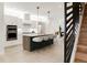 Modern kitchen with an island, stainless steel appliances, white cabinets, and an open layout leading to stairs at 4201 Vallejo St, Denver, CO 80211