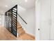 View of a staircase with black metal and wood bannister complemented by a custom divider and hardwood floors at 4201 Vallejo St, Denver, CO 80211