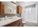 A bathroom with a wooden vanity, large mirror, and shower-tub combination with a polka dot curtain at 8201 Allison Ct, Arvada, CO 80005