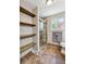 A bathroom featuring a glass-enclosed shower, open shelving, and brown tiled floors at 8201 Allison Ct, Arvada, CO 80005