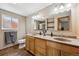 A bathroom featuring double sinks with wooden cabinetry and a separate shower area at 8201 Allison Ct, Arvada, CO 80005