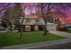 Charming home with a well-manicured lawn and a two-car garage against a beautiful sunset at 8201 Allison Ct, Arvada, CO 80005