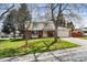 Inviting two-story home featuring a lush green lawn, mature trees, and an attached two-car garage at 8201 Allison Ct, Arvada, CO 80005