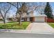 Charming two-story home features a well-maintained lawn, mature tree, and attached two-car garage at 8201 Allison Ct, Arvada, CO 80005