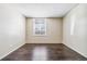 Well-lit bedroom with dark laminate flooring and window at 3339 S Monaco Pkwy # A, Denver, CO 80222