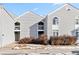 Exterior view of the light gray siding and second story balcony of a townhome with winter landscaping at 3339 S Monaco Pkwy # A, Denver, CO 80222