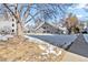 View of the exterior of the townhomes showing snow covered landscaping, and mature shade trees at 3339 S Monaco Pkwy # A, Denver, CO 80222