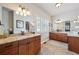 Bathroom featuring double vanities, granite countertops, and custom mirrors at 11064 Hermitage Run, Littleton, CO 80125