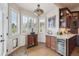 Charming breakfast nook with a built-in wine cooler, custom cabinets, and natural light from the bay window at 11064 Hermitage Run, Littleton, CO 80125
